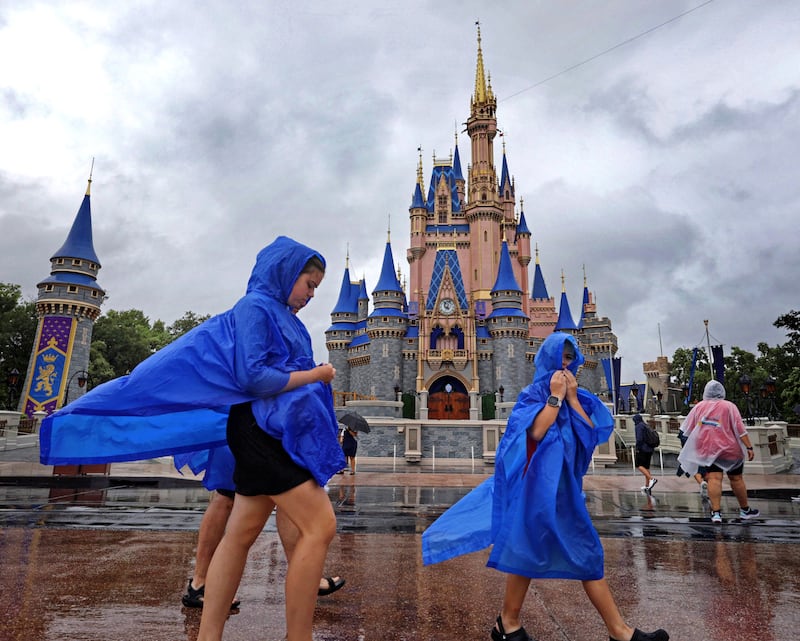 Vistiors at the Magic Kingdom at Walt Disney World brave the wind and rain (Joe Burbank/Orlando Sentinel/AP)