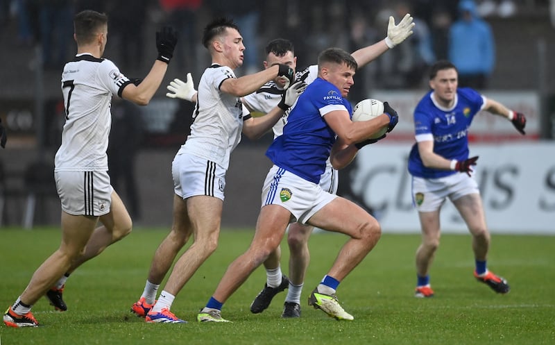 Clonoe players surround a Coalisland opponent.