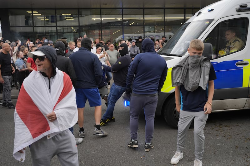 A man leans on a police van during an anti-immigration protest outside the Holiday Inn Express in Rotherham, South Yorkshire, on Sunday August 4