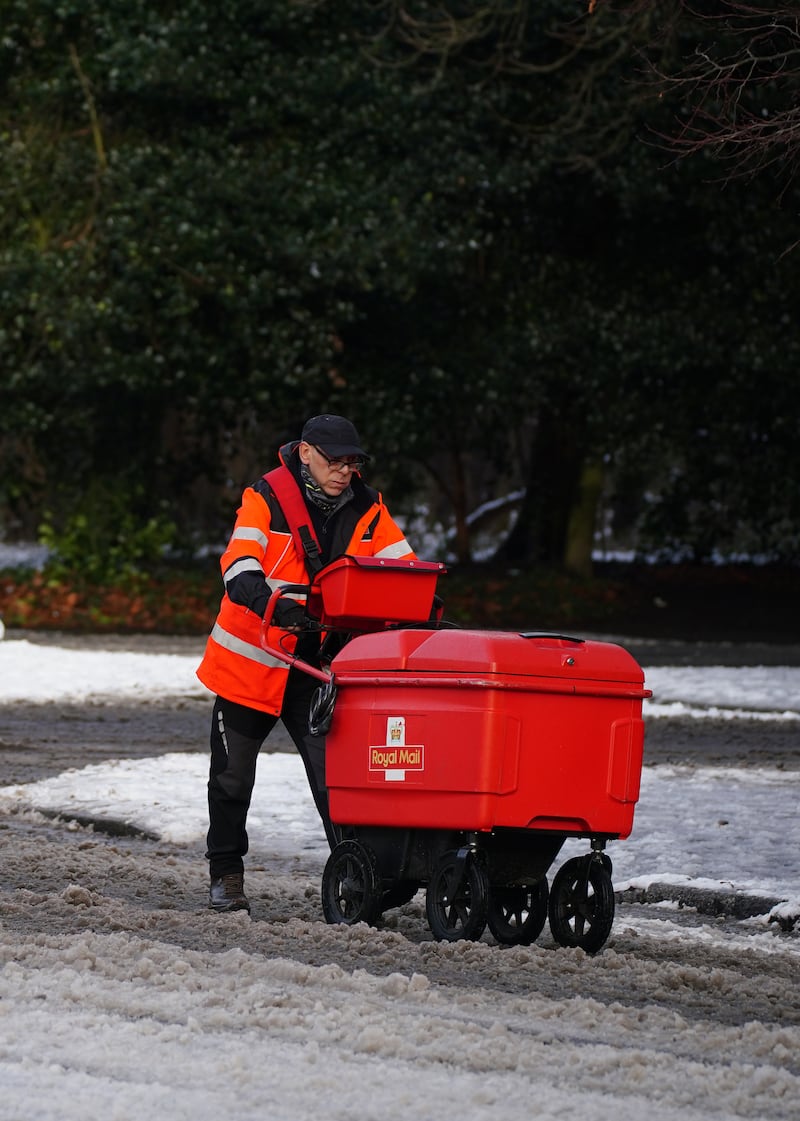 A postman battles through the snow in Sefton Park, Liverpool