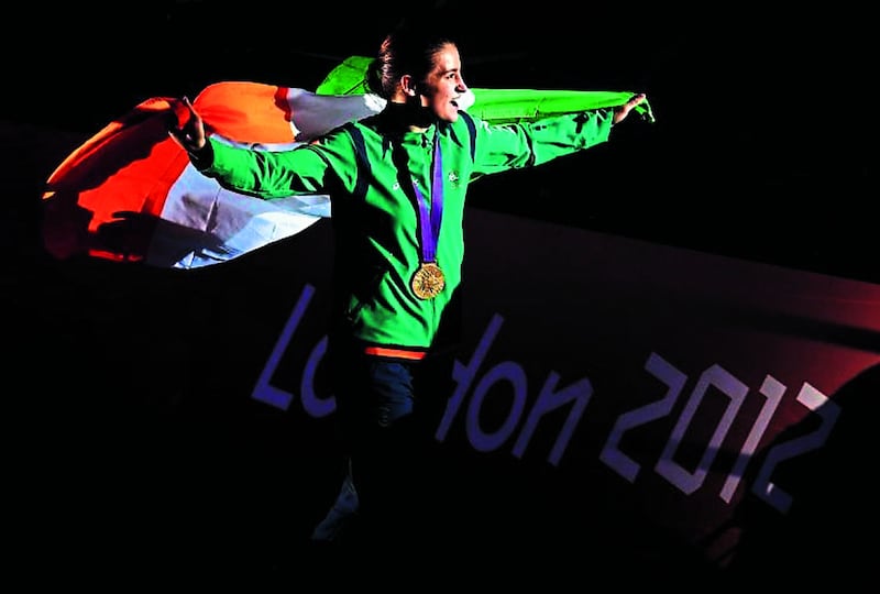 Katie Taylor with tricolour and gold medal at the 2012 London Olympics, at which she was the Irish squad's flag bearer Picture: Julien Behal/PA