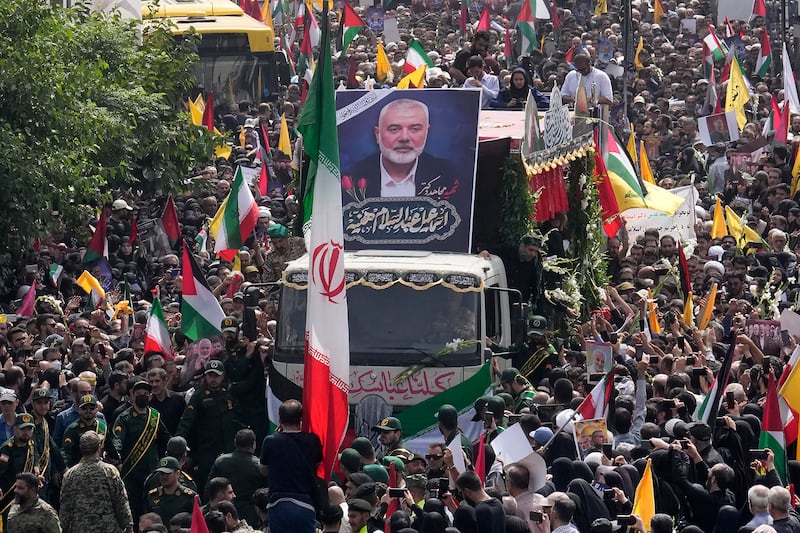 Iranians follow a truck, centre, carrying the coffins of Hamas leader Ismail Haniyeh and his bodyguard who were killed in an assassination blamed on Israel on Wednesday (Vahid Salemi/AP)