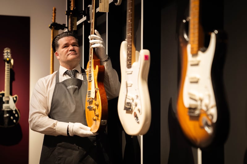 An art handler holds a 1959 Gibson Les Paul known as Yardburst