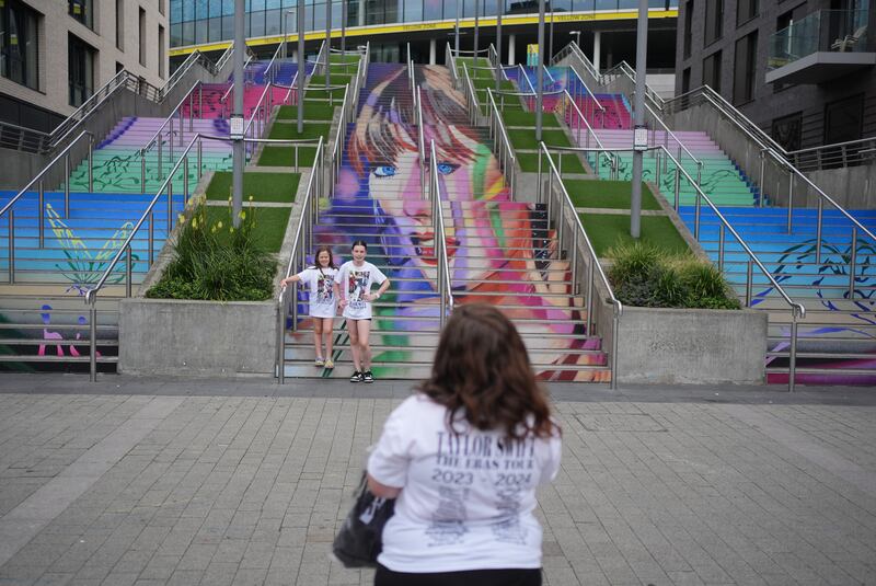 Eight-year-old Gracie Hiles and sister 12-year-old Jessica Evans pose as their mother takes their photograph at the Swiftie Steps and murals at Wembley