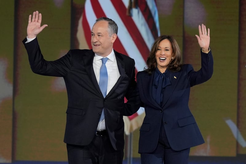 Second gentleman Doug Emhoff, left, and Democratic presidential nominee Vice President Kamala Harris wave at the conclusion of her speech (J Scott Applewhite/AP)