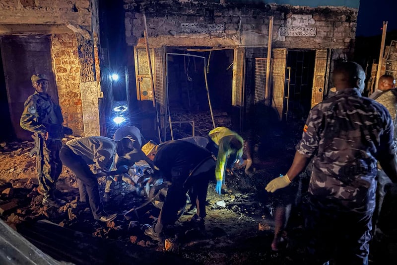 Uganda forensic officials inspect the site where the fuel truck exploded (AP)