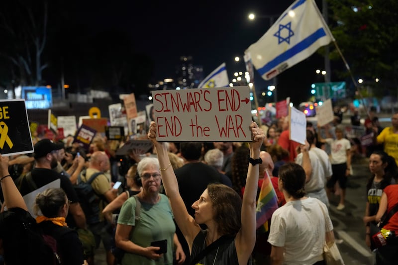 A demonstrator in Tel Aviv, Israel, holds a sign about the killing of Hamas leader Yahya Sinwar during a protest calling for a ceasefire deal and the immediate release of hostages held by Hamas (Ariel Schalit/AP)