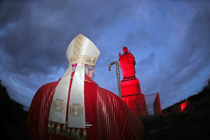 Bishop of Down and Connor, the Very Reverend Alan McGuckian, at the illumination in red of the world's tallest statue of St Patrick last night.  Bishop McGuckian gave permission for the Saul monument at Slieve Patrick, County Down, Ireland  to be lit red, the colour of martyrdom, for the first time in solidarity with persecuted Christians. Cathedrals, Churches and landmarks such as the Colosseum in Rome are lit red at the invitation of the charity, Aid to a Church in Need, which organises an annual  Week of Witness particularly on Red Wednesday (November 20). Saul Monument, which rises to 47 feet, was built in the 1930s to mark the 1500th anniversary of St Patrick's arrival in the area to begin his Christian mission in Ireland in 432AD.After visiting the monument, Bishop McGuckian told parishioners at the vigil mass at St Patrick's, Saul: " Remember to pray for our brothers and sisters all over the world who at this very moment, this very day, are being persecuted for boasting that ‘Jesus Christ is Lord’
PICTURE BILL SMYTH