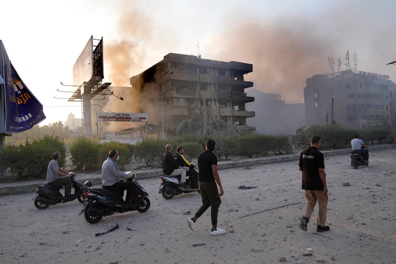 People pass buildings destroyed by Israeli air strike in Dahiyeh, Beirut, Lebanon (Hussein Malla/AP)