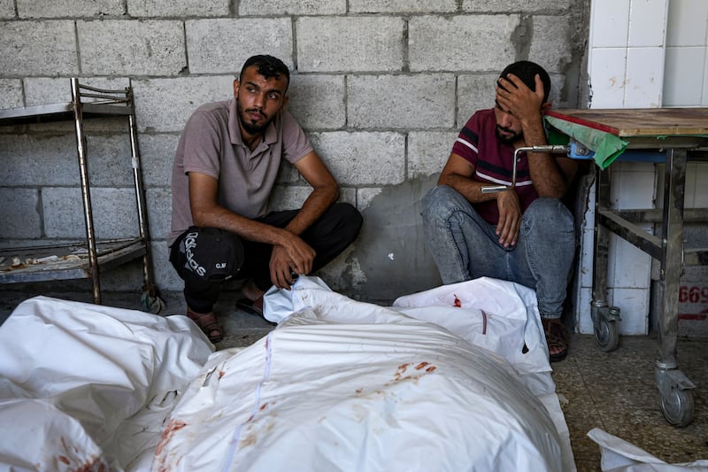 Palestinians mourn relatives killed in the Israeli bombardment of the Gaza Strip, at a hospital in Deir al-Balah (Abdel Kareem Hana/AP)