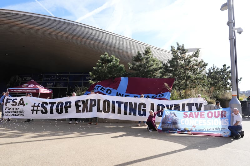 Fans hold up an FSA banner reading “Stop Exploiting Loyalty” outside the London Stadium ahead of the Premier League match between West Ham and Manchester United