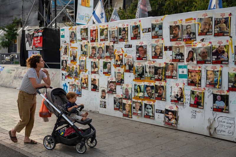 Photos of hostages held in the Gaza Strip on a wall in Tel Aviv, Israel (Oded Balilty/AP)