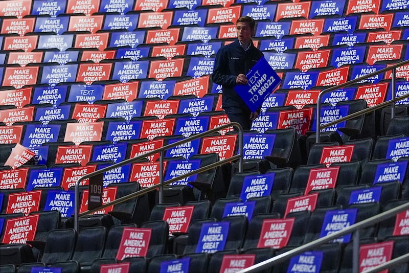 Workers place signs in seats before Donald Trump speaks at a campaign rally at Madison Square Garden, New York, on Sunday (Julia Demaree Nikhinson/AP)