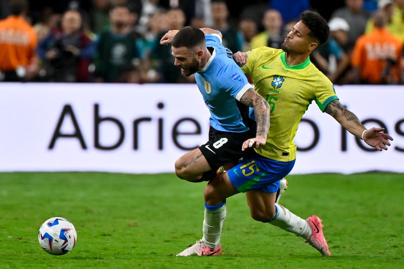 Uruguay’s Nahitan Nandez (8) and Brazil’s Joao Gomes battle for the ball (David Becker/AP)