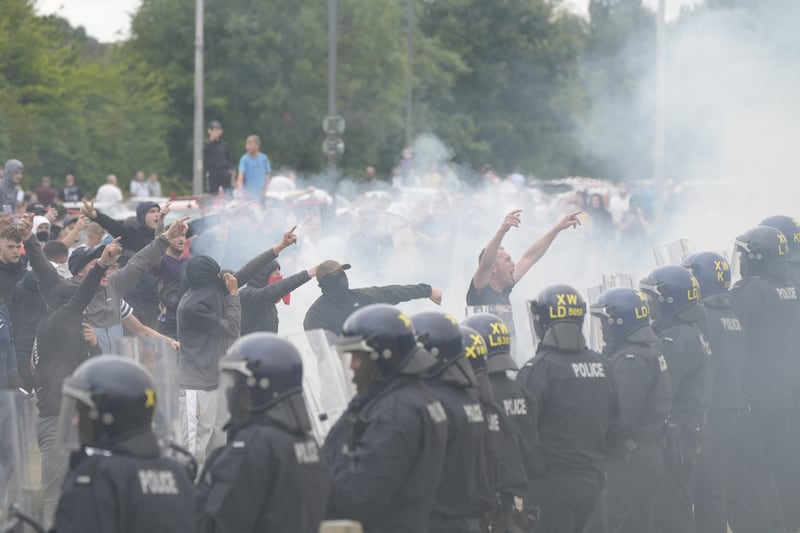 Police officers face protesters during an anti-immigration demonstration outside the Holiday Inn Express in Rotherham, South Yorkshire, on Sunday