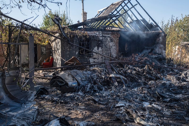 A damaged private house in the background of fragments of a shot down Russian military plane (Iryna Rybakova via AP)