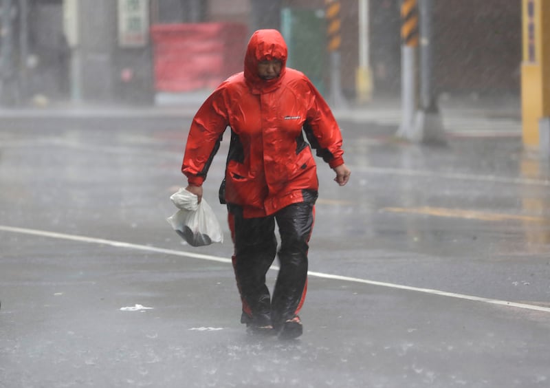 A woman struggles in the wind and rain generated by Typhoon Krathon in Kaohsiung, southern Taiwan (Chiang Ying-ying/AP)