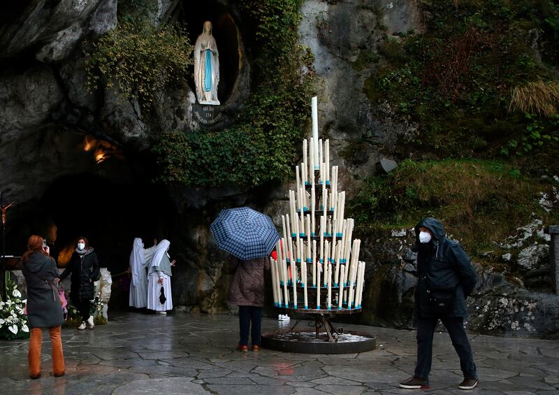 Pilgrims pray at the Roman Catholic shrine in Lourdes, southwestern France (Bob Edme/AP)