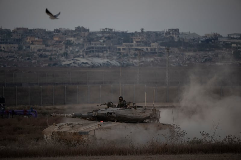 Israeli soldiers move on the top of a tank near the Israeli-Gaza border, as seen from southern Israel. (Leo Correa/AP)