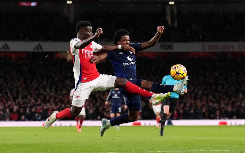 Tyrell Malacia (right) challenges Arsenal’s Bukayo Saka