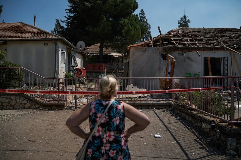 A woman looks at a damaged house that was hit by a rocket fired from Lebanon, near Safed, northern Israel (Leo Correa/AP)