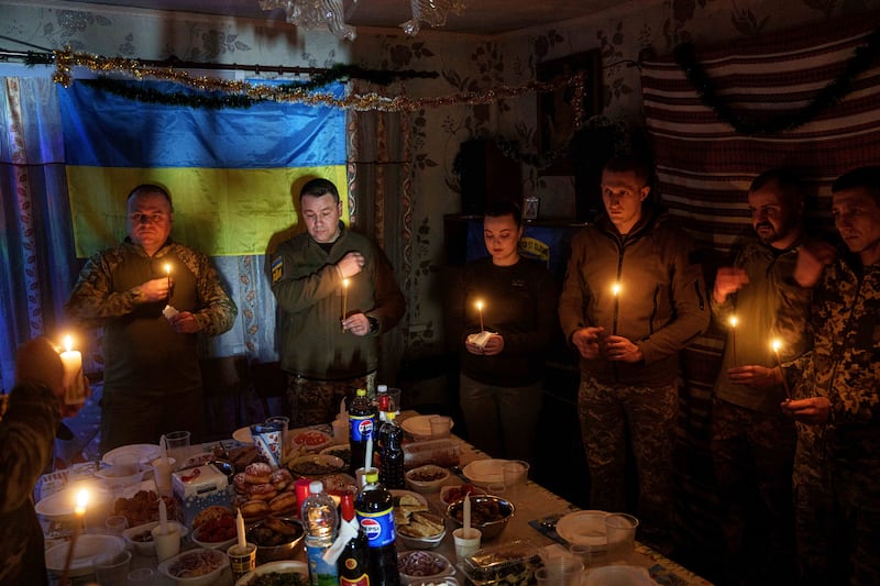 Ukrainian servicemen praying before a Christmas dinner in Donetsk (AP Photo/Evgeniy Maloletka)