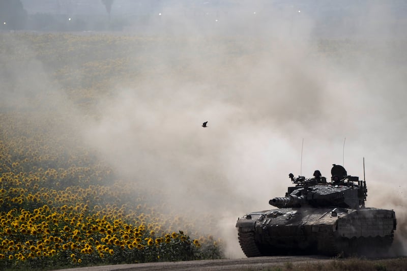 Israeli soldiers move on the top of a tank near the Israeli-Gaza border, as seen from southern Israel (Leo Correa/AP)