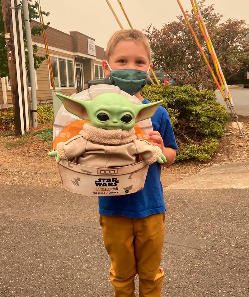 Five-year-old Carver holds up a Baby Yoda toy in Scappoose, Oregon