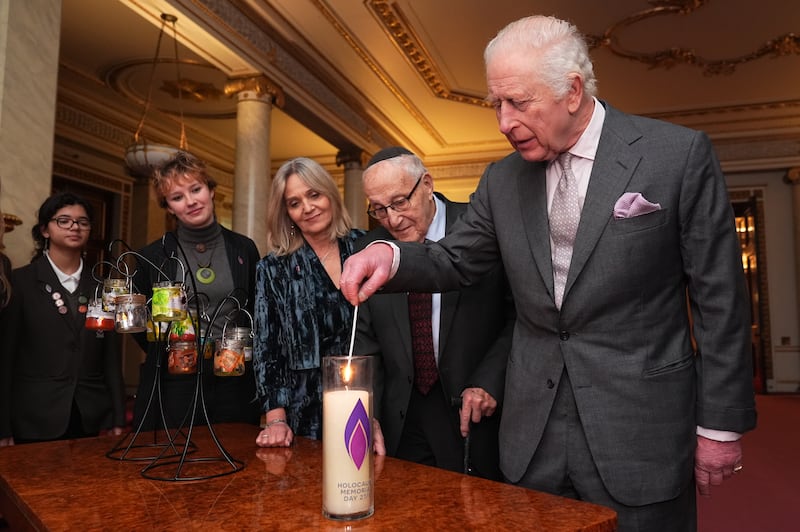 Charles lights a candle during a reception marking Holocaust Memorial Day, when he said that the upcoming visit to Auschwitz-Birkenau as ‘so important’