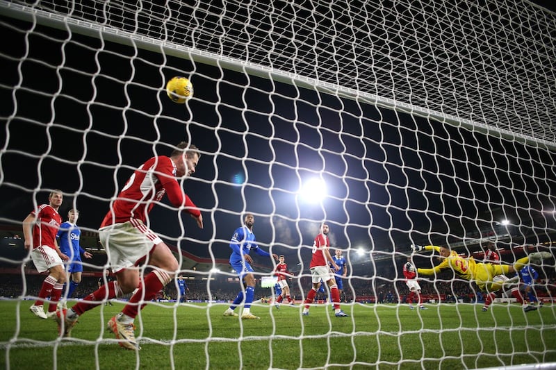 Dwight McNeil, obscured right, scores Everton's winner