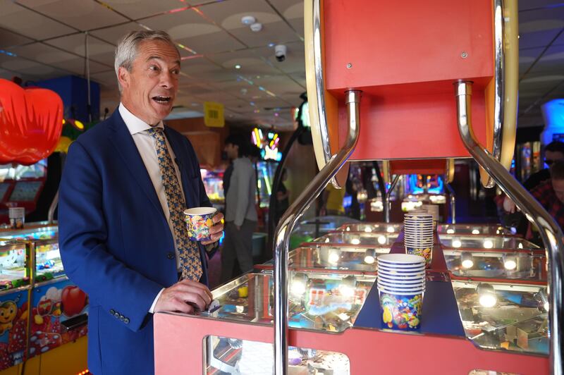 Nigel Farage playing a 2p machine in Clacton-on-Sea while on the General Election campaign trail