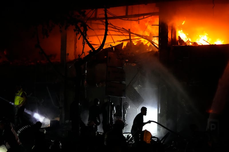 Civil defence workers extinguish a fire at the site of an Israeli airstrike in Beirut (Hassan Ammar/AP)