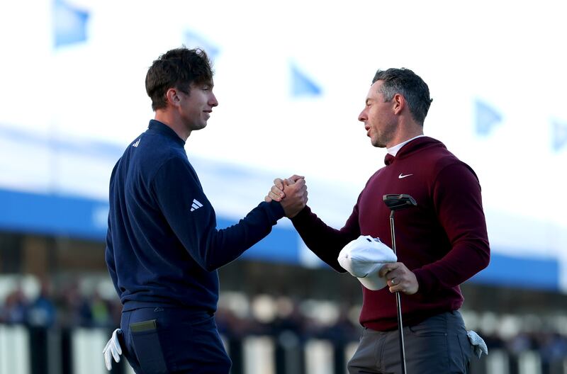 Rory McIlroy and Tom McKibbin clasp hands at the end of their opening Irish Open round in Newcastle. Picture by Luke Walker/Getty Images