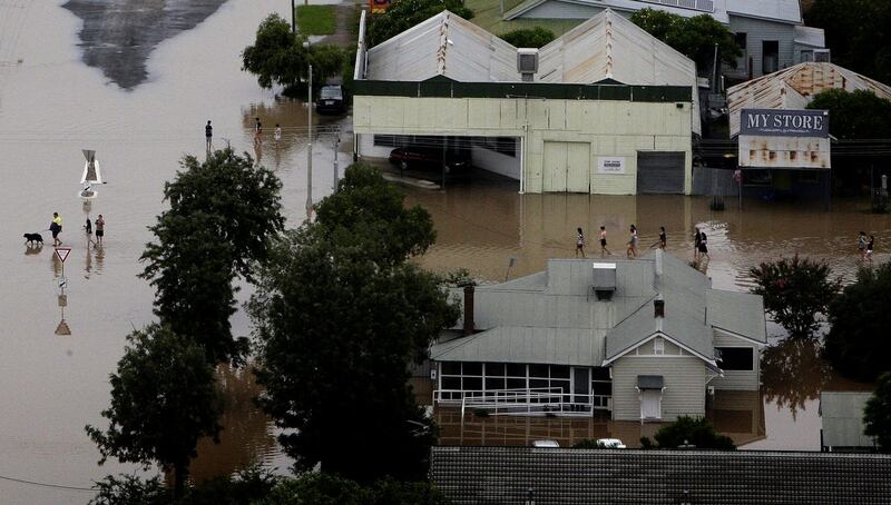 People wade through floodwaters in the town of Moree, northern New South Wales, Australia 