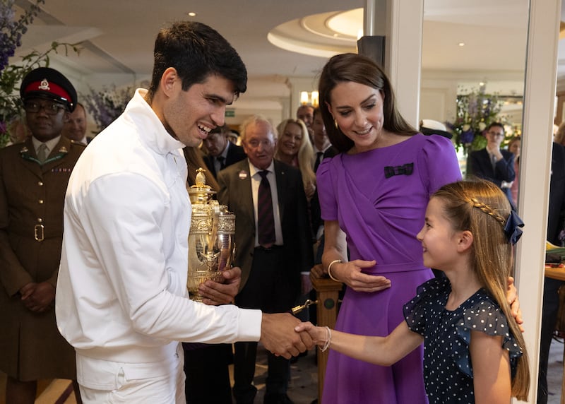 The Princess of Wales, patron of the All England Lawn Tennis Club, looks on as Princess Charlotte shakes hands with Carlos Alcaraz (AELTC/Andrew Parsons)