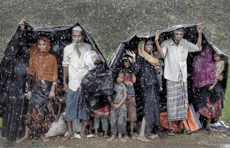 Rohingya refugees shelter from the rain in a camp in Cox&#39;s Bazar, Bangladesh, September 17 2017. Picture by Cathal McNaughton 