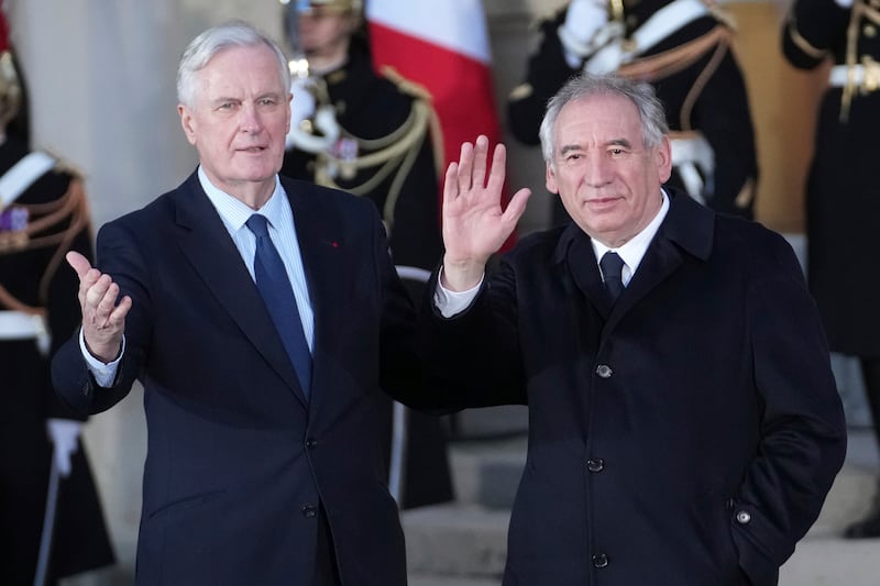 Outgoing French Prime Minister Michel Barnier, left, welcomes newly named Prime Minister Francois Bayrou (Christophe Ena/AP)