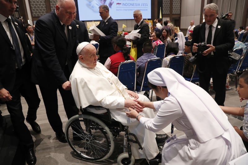 Pope Francis is greeted by a Catholic nun during a meeting with beneficiaries from charitable organisations at the Indonesian Bishops’ Conference Headquarters (Adi Weda/AP)