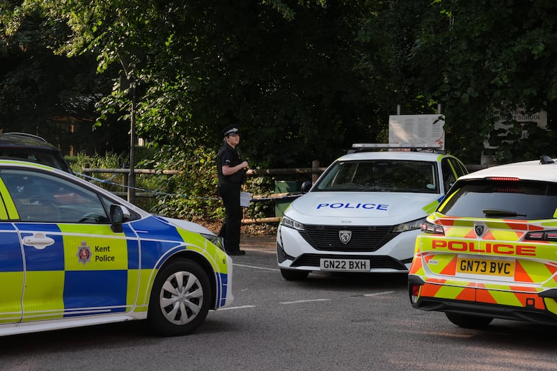 Police vehicles beside a cordon at the scene in Sally Port Gardens