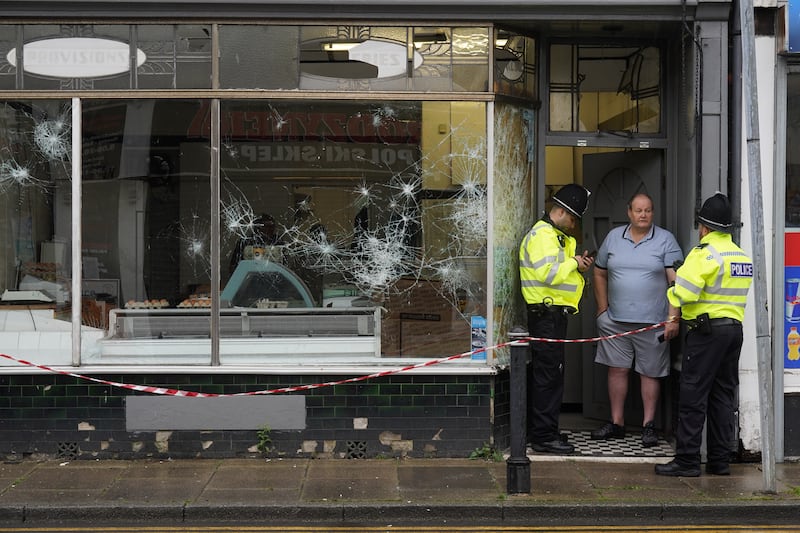 Police officers outside a damaged butchers shop on Murray Street in Hartlepool following a violent protest on Wednesday evening