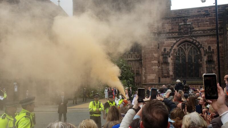 A protester using a fire extinguisher to project powder paint outside Chester Cathedral during the wedding of Hugh Grosvenor, the Duke of Westminster, and Olivia Henson