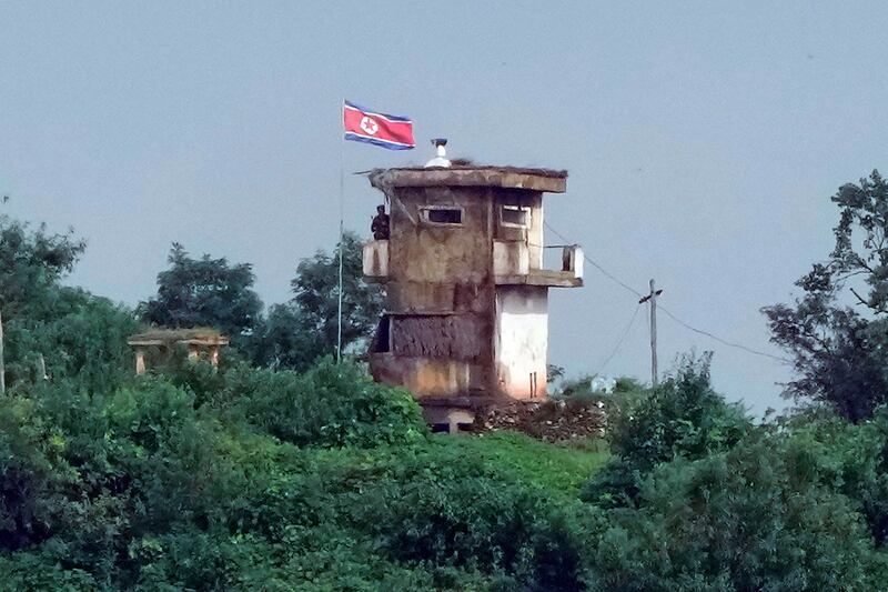 A North Korean soldier stands at the North’s military guard post as a North Korean flag flutters in the wind, in this view from Paju, South Korea, on Wednesday (Ahn Young-Joon/AP)