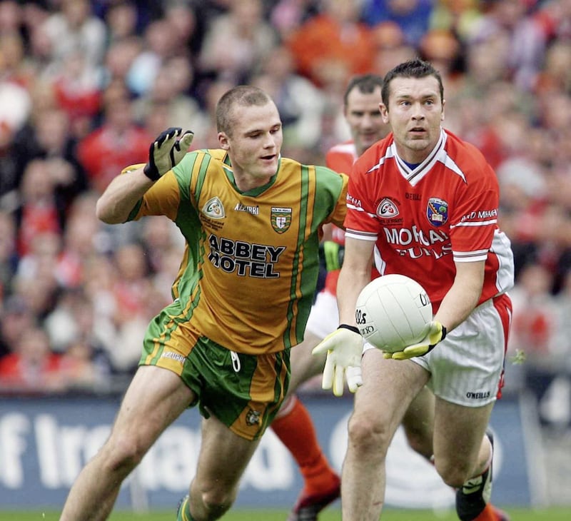 Oisin McConville gets a pass away despite the pressure from Donegal&#39;s Neil McGee 