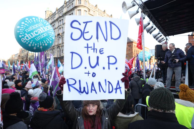 A striking worker holds a sign outside Belfast City Hall, Belfast