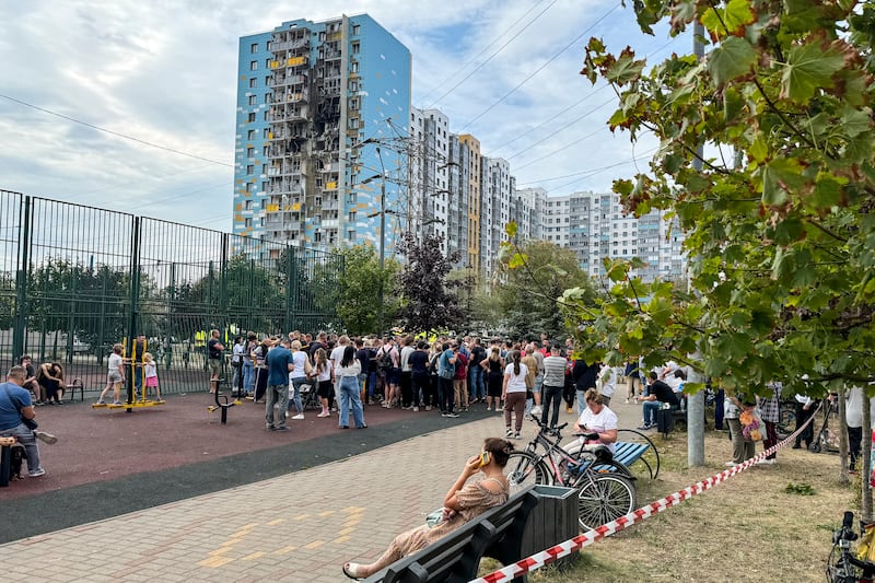 People gather to talk to local officials at the site of the damaged residential building, following an alleged Ukrainian drone attack in Ramenskoye, outside Moscow, Moscow region (AP)