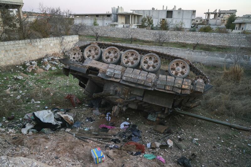 A Syrian army armoured vehicle sits upside-down in the village of Hass, near Aleppo on November 30 (AP Photo/Omar Albam)