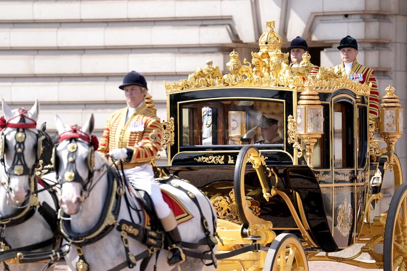 The King salutes the Life Guards as he and the Queen leave Buckingham Palace in the Diamond Jubilee State Coach to travel to the State Opening of Parliament