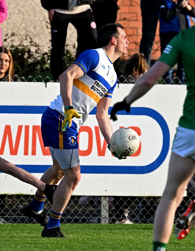 Errigal Ciaran's  Aidan McCrory makes a hand-pass against Cargin.