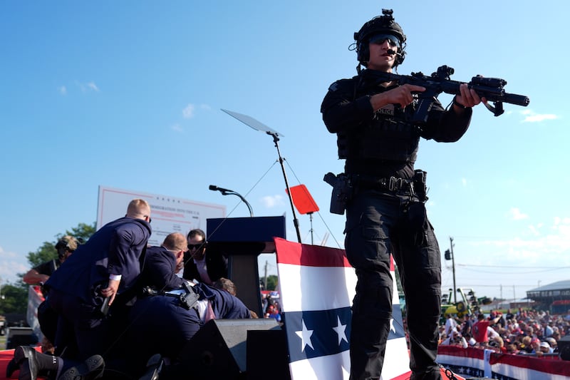 Donald Trump is covered by US Secret Service agents at the campaign rally in Butler, Pennsylvania (Evan Vucci/AP)