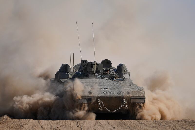 An Israeli armoured personnel carrier on manoeuvres near the Gaza Strip border (AP)
